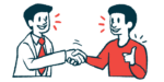 Two people shake hands to show collaboration.