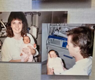 Two small photographs, neither framed, are posted on a gray wall, slightly overlapping. The photo on the left shows a mom with curly brown hair holding her newborn baby. The dad is holding the baby in the other photo. Both photos were taken in the neonatal intensive care unit, so various machines and medical devices can be seen in the background. The baby is very tiny, as she was born prematurely.