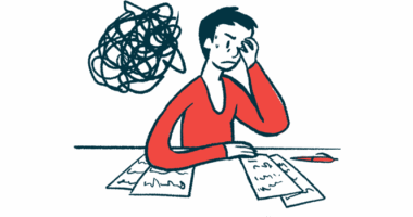 A person sitting at a table holds her head in her hands.