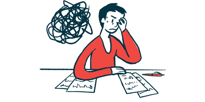 A person sitting at a table holds her head in her hands.